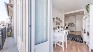 Un appartement moderne doté d’un balcon, d’un coin repas et d’une cuisine.