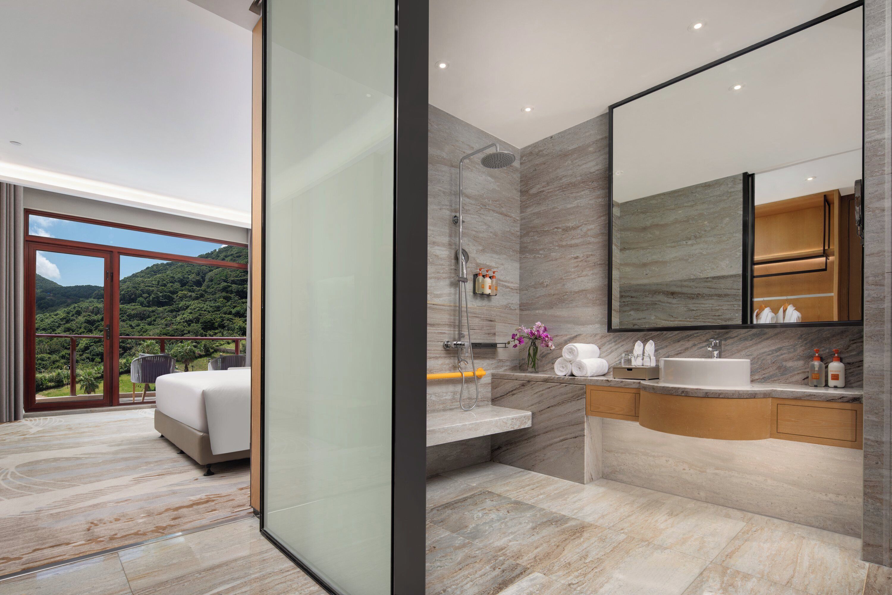 A modern bathroom with a large mirror, a shower, and a sink.