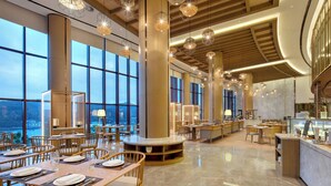 Un restaurante espacioso con techos altos, ventanas amplias y modernos elementos de iluminación.