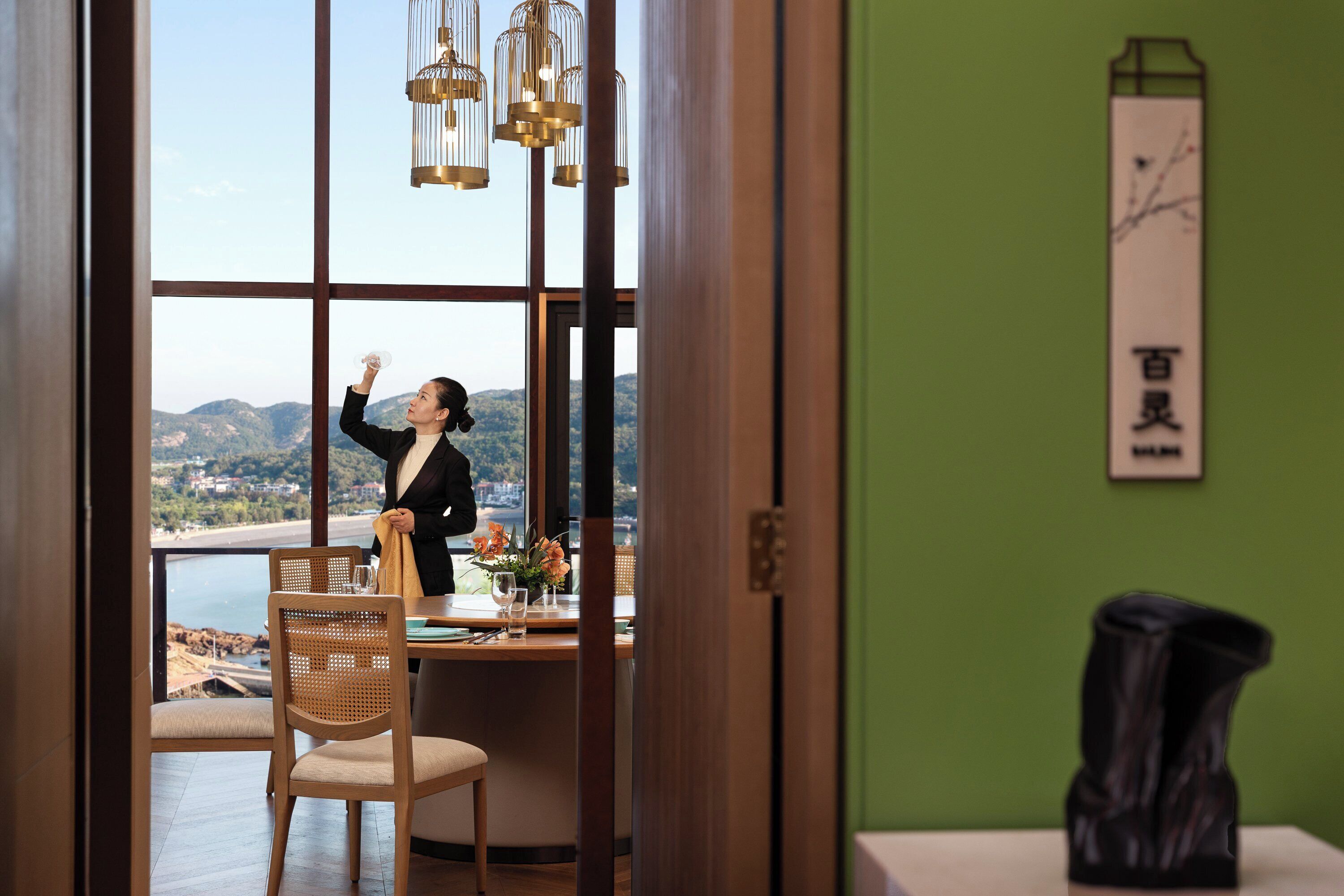 Une pièce dotée d’une grande fenêtre donnant sur un paysage magnifique, d’une table à manger avec des chaises et d’un élément décoratif au mur.