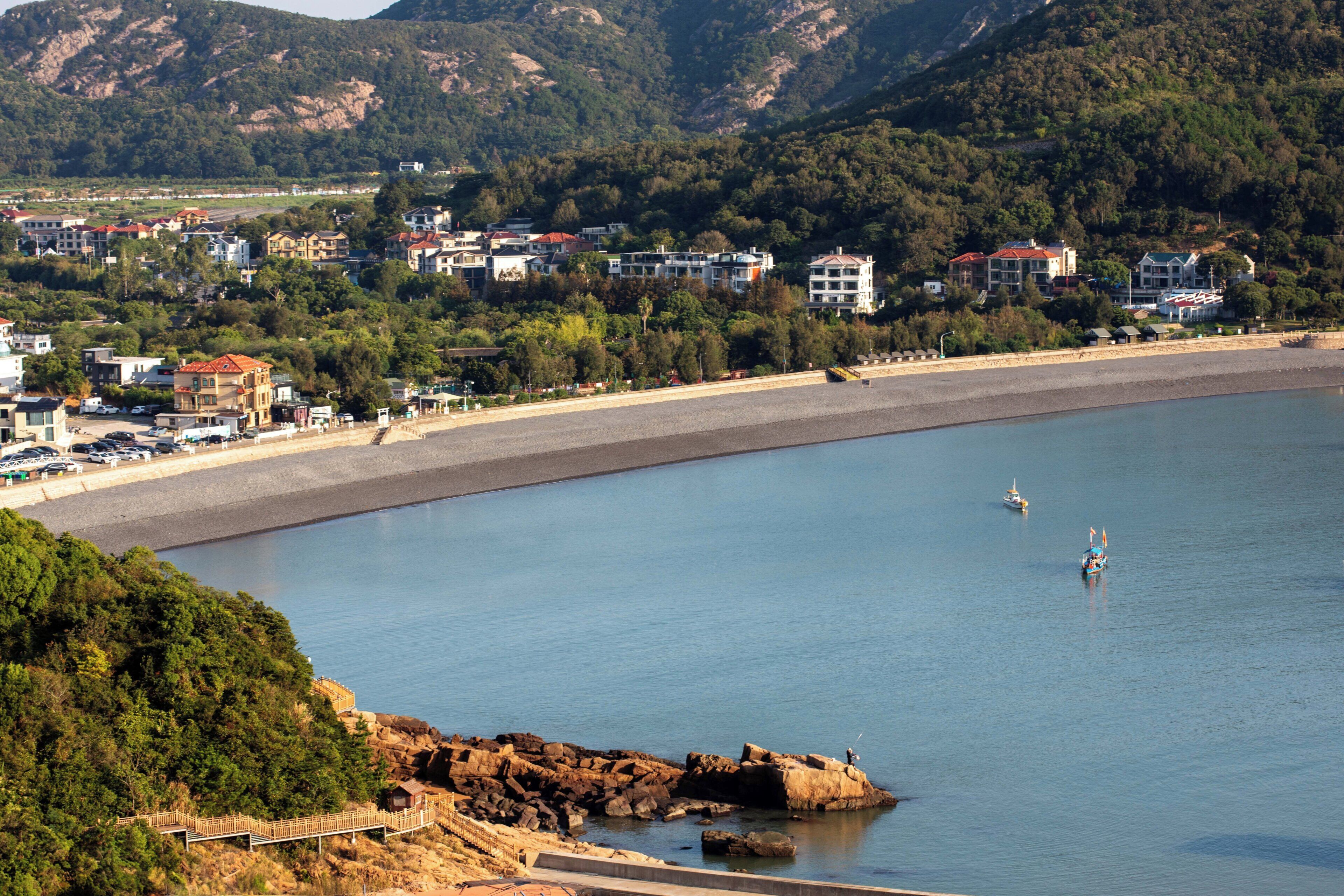 Une ville côtière dotée d’une plage, d’une côte rocheuse et d’immeubles d’habitation.