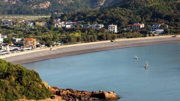 Une ville côtière dotée d’une plage, d’une côte rocheuse et d’immeubles d’habitation.