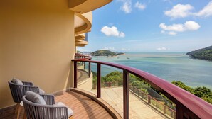 Un balcón con barandilla curva que da a vistas de la costa.