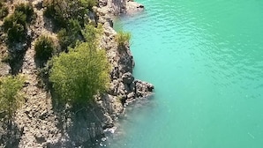 Een rivier met helder turquoise water, omringd door rotsachtige kliffen en weelderige groene begroeiing.