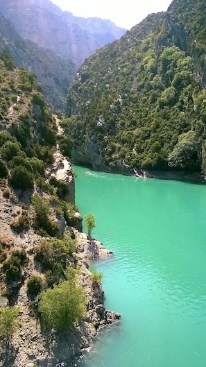 Een rivier met helder turquoise water, omringd door rotsachtige kliffen en weelderige groene begroeiing.