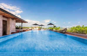 A swimming pool with a clear blue water surface, surrounded by lounge chairs and umbrellas, and a stone building with a covered patio area. - The Yucatan Playa del Carmen, Tapestry Collection by Hilton (Playa del Carmen)
