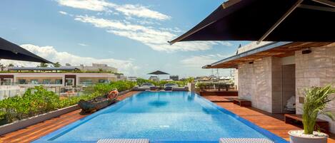 Een buitenzwembad en ligstoelen