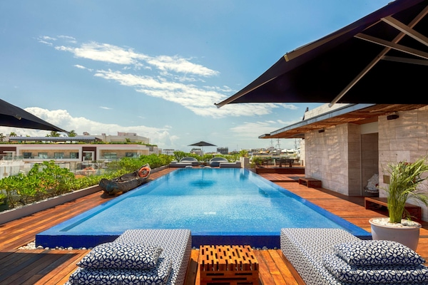 Una piscina al aire libre, sillones reclinables de piscina