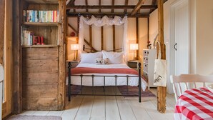 A cozy bedroom with a wooden bookshelf, a bed with white linens, and a red checkered tablecloth. - The Granary by Bloom Stays - cute lodge sleeps 2 guests  in 1 bedroom (Canterbury)