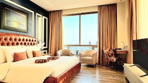 A hotel room with a large bed, two armchairs, a desk, and a large window with curtains. - Best Western Premier Hotel Gulberg Lahore (Lahore)