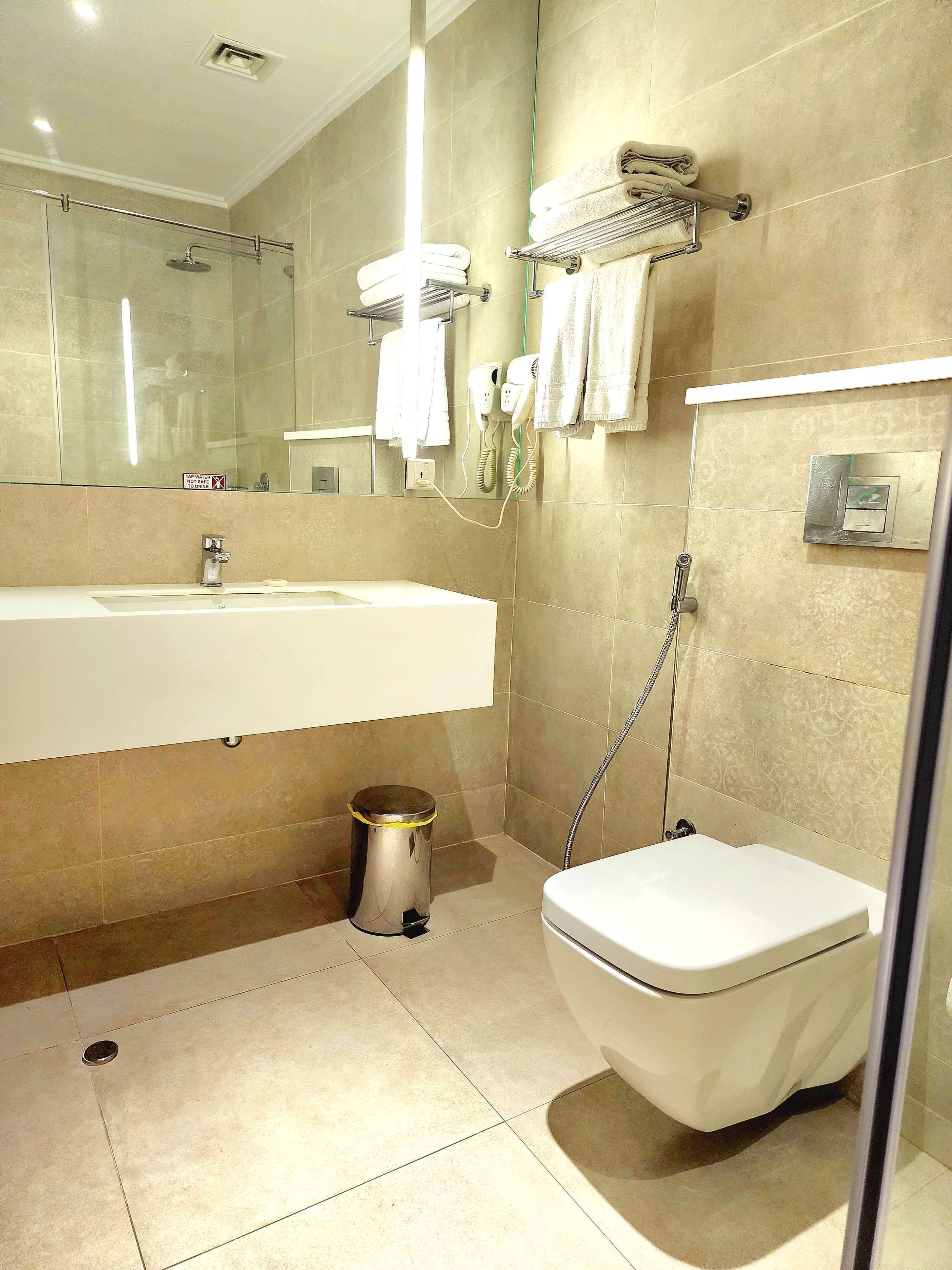 A modern bathroom with a sink, toilet, and shower.