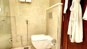 Un baño moderno con ducha de vidrio, inodoro blanco y puerta de madera.