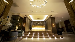 A modern hotel lobby with a central reception desk, marble steps, and contemporary lighting fixtures. - Best Western Premier Hotel Gulberg Lahore (Lahore)