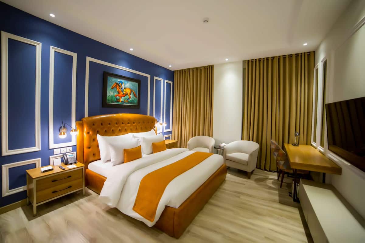 Una habitación de hotel moderna con una cama grande, un escritorio y una silla.