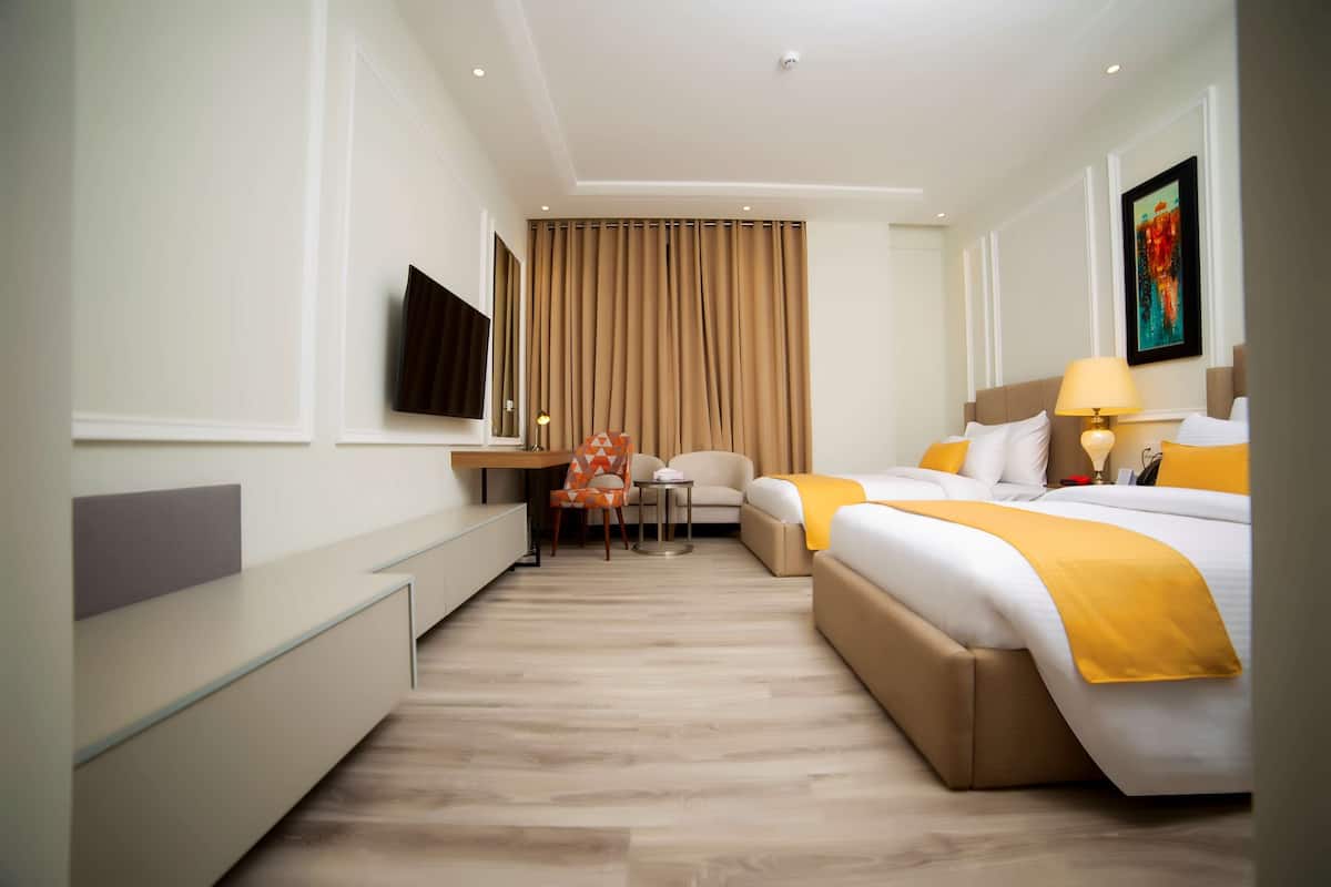 Una habitación de hotel con cama, escritorio, silla y televisión.