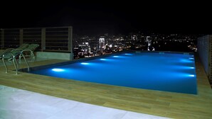 A rooftop infinity pool with a city view at night. - Best Western Premier Hotel Gulberg Lahore (Lahore)