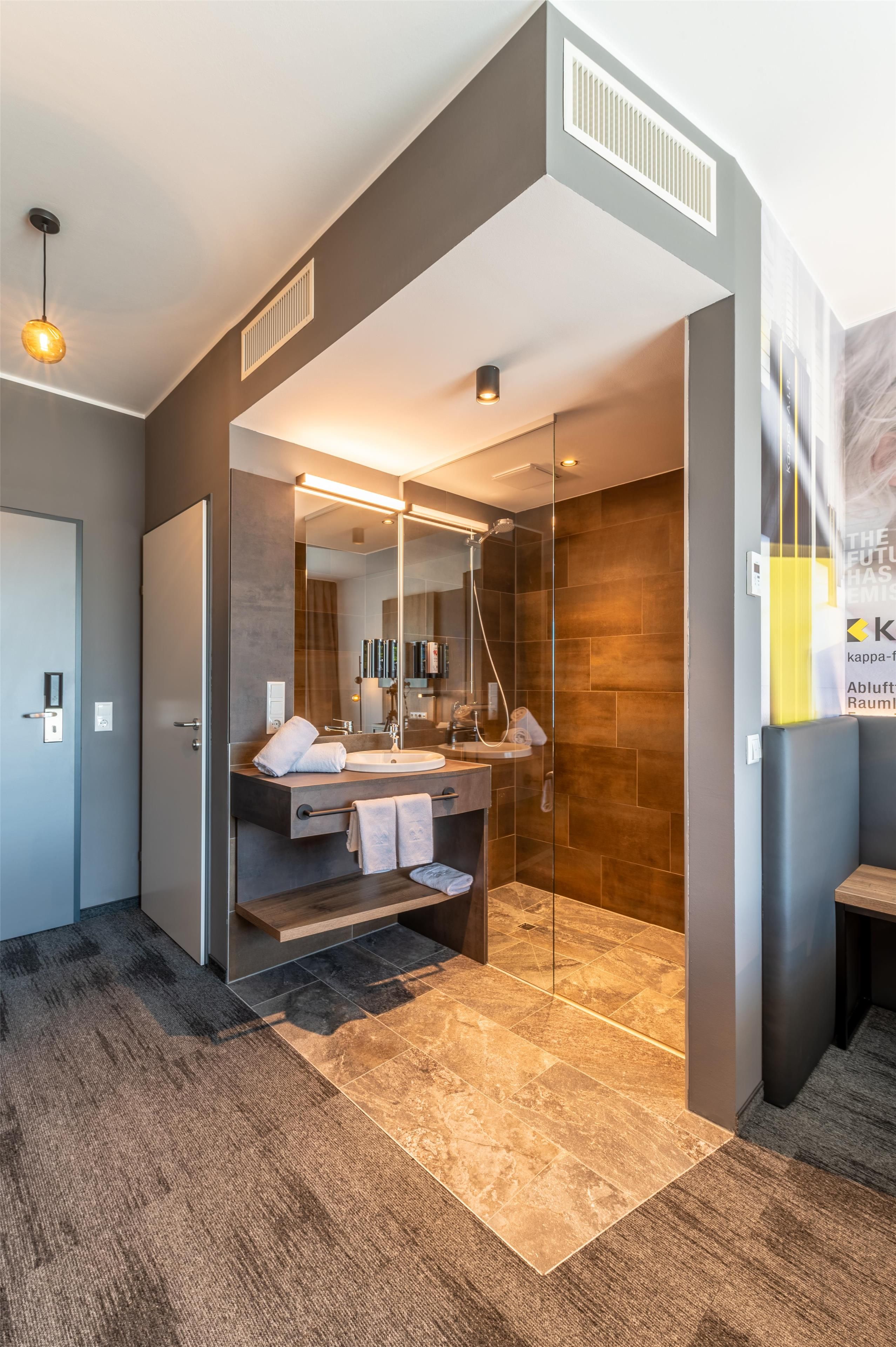 A modern bathroom with a glass-enclosed shower, a vanity with a mirror, and a towel rack.