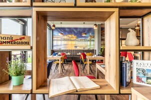 A modern interior with wooden furniture, a mural of a cityscape, and a sign that reads "thank ZIMMERGLOCKE".