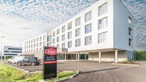 A modern hotel building with a sign for 'Aiden by Best Western' and a parking lot. - Aiden by Best Western Stadtgut Hotel Steyr (Steyr)