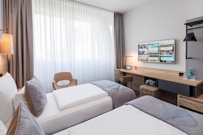 Una habitación de hotel con una cama, un escritorio, una silla y un televisor mostrando un menú.