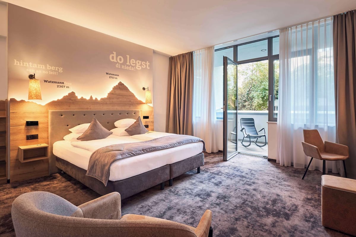 Een moderne hotelkamer met een groot bed, een bureau en uitzicht op de omgeving.