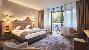 Ein modernes Hotelzimmer mit einem großen Bett, einem Schreibtisch und Blick ins Freie.