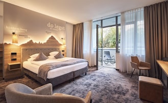 Una camera d'albergo moderna con un letto grande, una scrivania e vista sull'esterno.