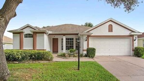 A two-story house with a garage, a front porch, and a well-maintained lawn.