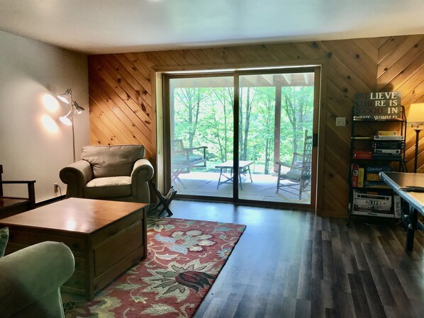 A cozy living room with a wooden floor, a sofa, a coffee table, and a bookshelf.