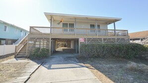 A two-story building with a balcony, a staircase, and a parking sign. - This welcoming home is great for small families. (Duck)