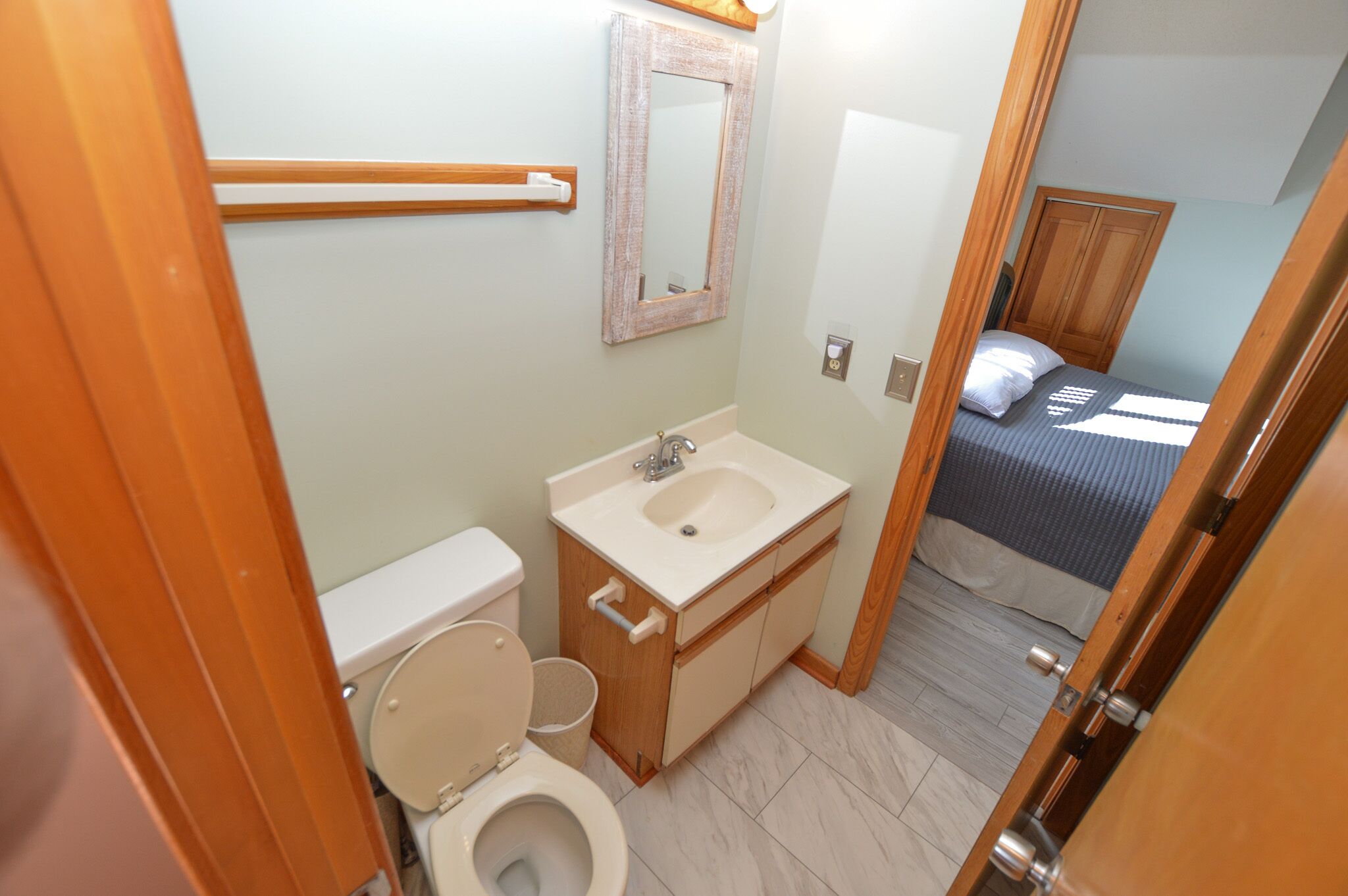 A small bathroom with a toilet, sink, and mirror.