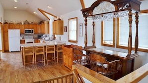 A spacious kitchen with wooden cabinetry, a central island with bar stools, and a chandelier. - When it is time to Set Back & Relax, you have found the vacation rental home to do just that. (Corolla)
