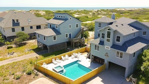 A large house with a swimming pool, multiple decks, and a view of the ocean. - Dreamcatcher is a well-equipped vacation home perfect for a terrific vacation experience. (Corolla)