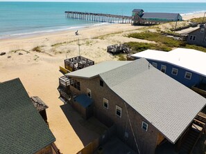 Una propiedad frente a la playa con una casa grande, un muelle y una playa.