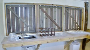 Una cocina con encimera de madera, un lavamanos y un cubo de basura.