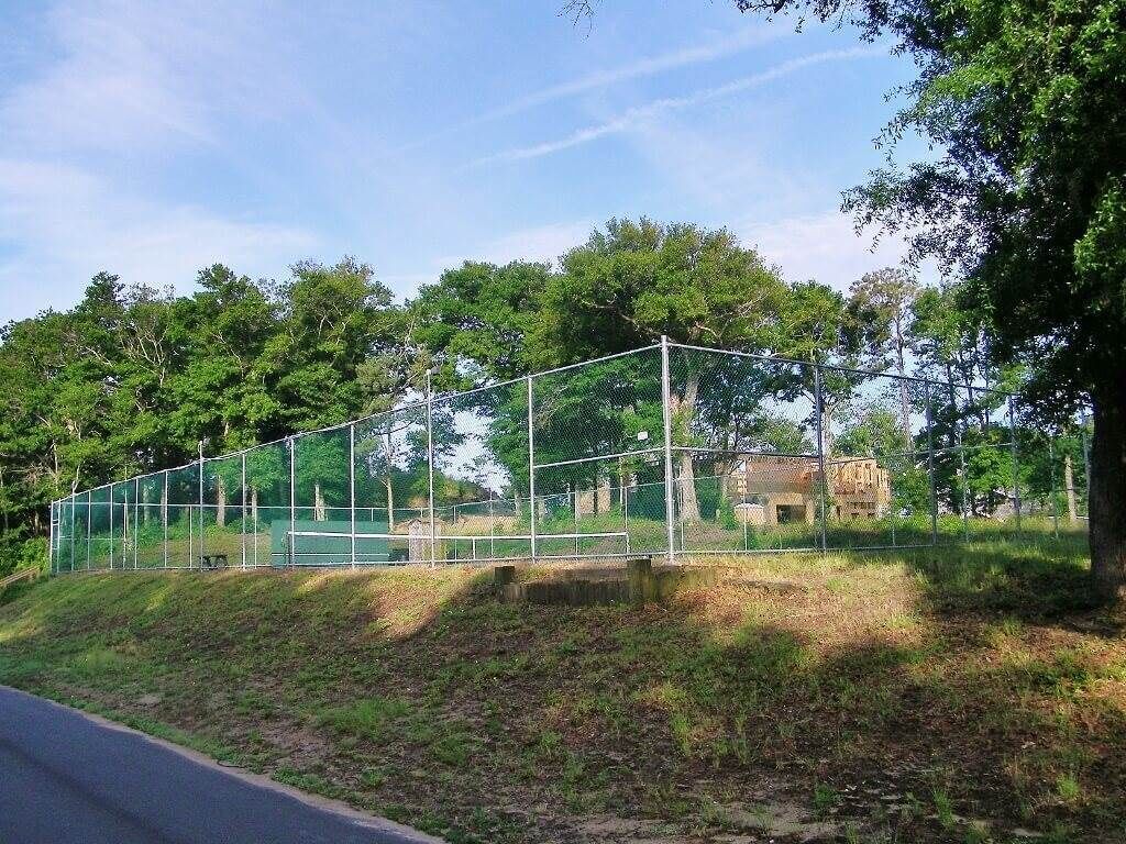 Zona delimitada amb pendent herbós i arbres al fons.