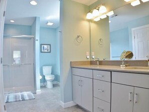 Une salle de bain équipée d’une douche, de toilettes et d’un meuble-lavabo avec un miroir.