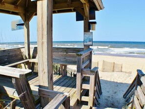 A wooden beach deck with a view of the ocean.