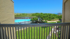 A view of a swimming pool with a wooden deck and a gazebo in the background.