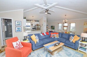 A living room with a sectional sofa, a coffee table, and a ceiling fan. - Life's a breeze and your vacation will be too in this lovely home. (South Nags Head)