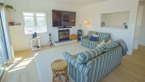 A living room with a television, sofa, and fireplace.