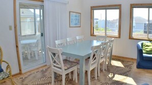 A dining area with a table and chairs, a sliding glass door, and a view of the outside.