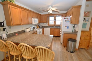 Enjoy cooking in this well-equipped kitchen with a central island, microwave, toaster, sink, and refrigerator.