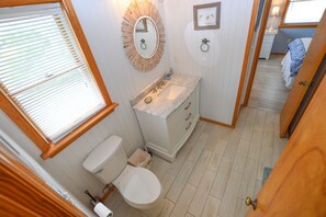 Un baño pequeño con inodoro, lavamanos y tocador.