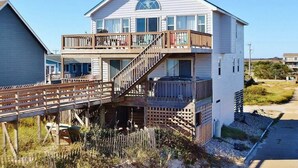 Une maison à deux étages avec un balcon et une terrasse en bois.