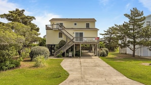 A two-story residential building with a covered walkway, a small porch, and a visible garage door.