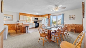 A compact kitchen with wooden cabinets, a microwave, and a refrigerator.