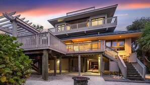 A multi-level house with a balcony, a covered patio, and a fire pit. - Stella Marris- N. Captiva Island | Luxury Beachfront Retreat (Lee County)