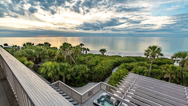 A wooden deck with a hot tub and a view of the ocean. - Stella Marris- N. Captiva Island | Luxury Beachfront Retreat (Lee County)