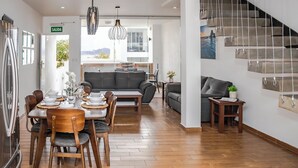 A modern kitchen with a dining area, a staircase, and a living room with a sofa and a coffee table. - Turquesa 1 Joyas del mar San Carlos (San Carlos)